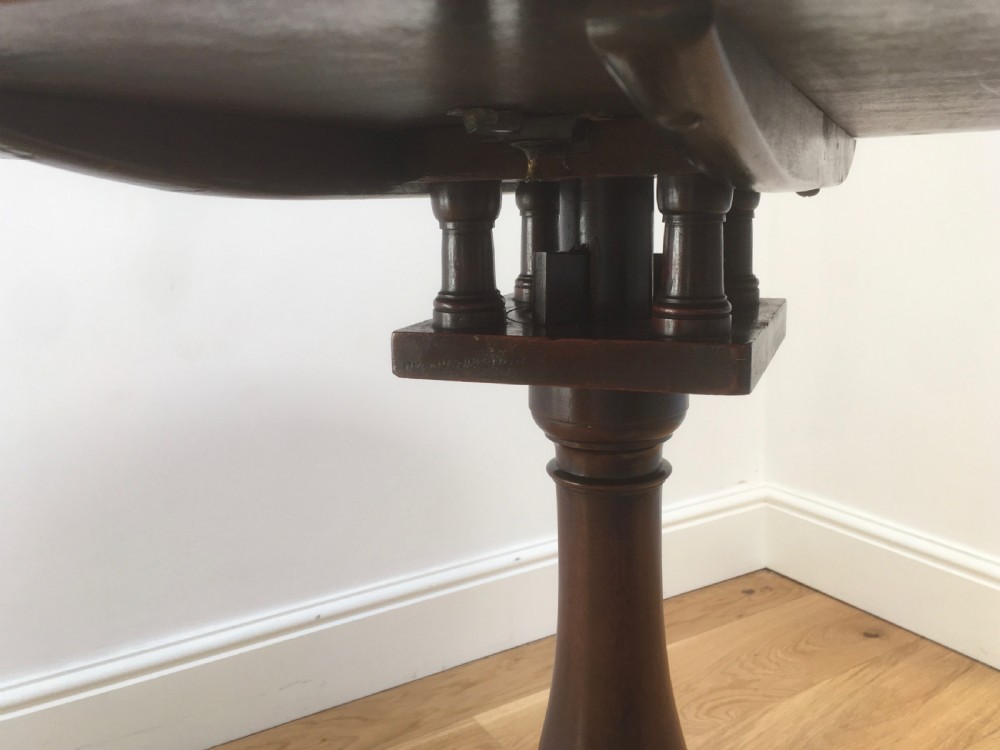 A Georgian mahogany tilt top table featuring a circular top, turned central pedestal, and tripod cabriole legs. View V