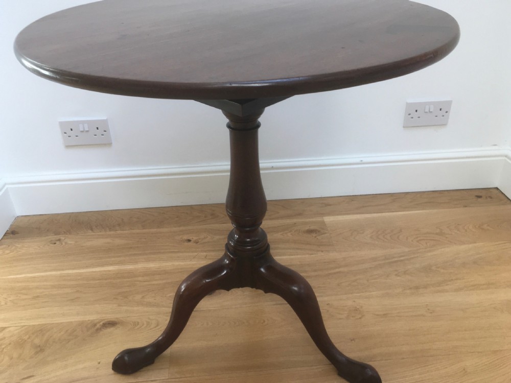 A Georgian mahogany tilt top table featuring a circular top, turned central pedestal, and tripod cabriole legs. View VI