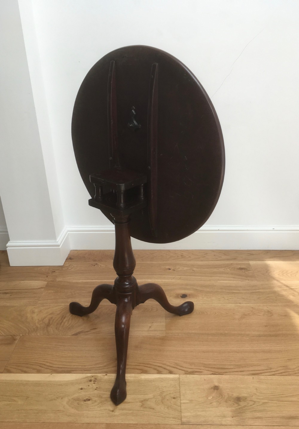 A Georgian mahogany tilt top table featuring a circular top, turned central pedestal, and tripod cabriole legs. View VIII