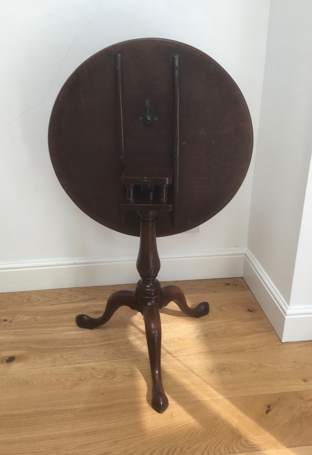 A Georgian mahogany tilt top table featuring a circular top, turned central pedestal, and tripod cabriole legs. View IX