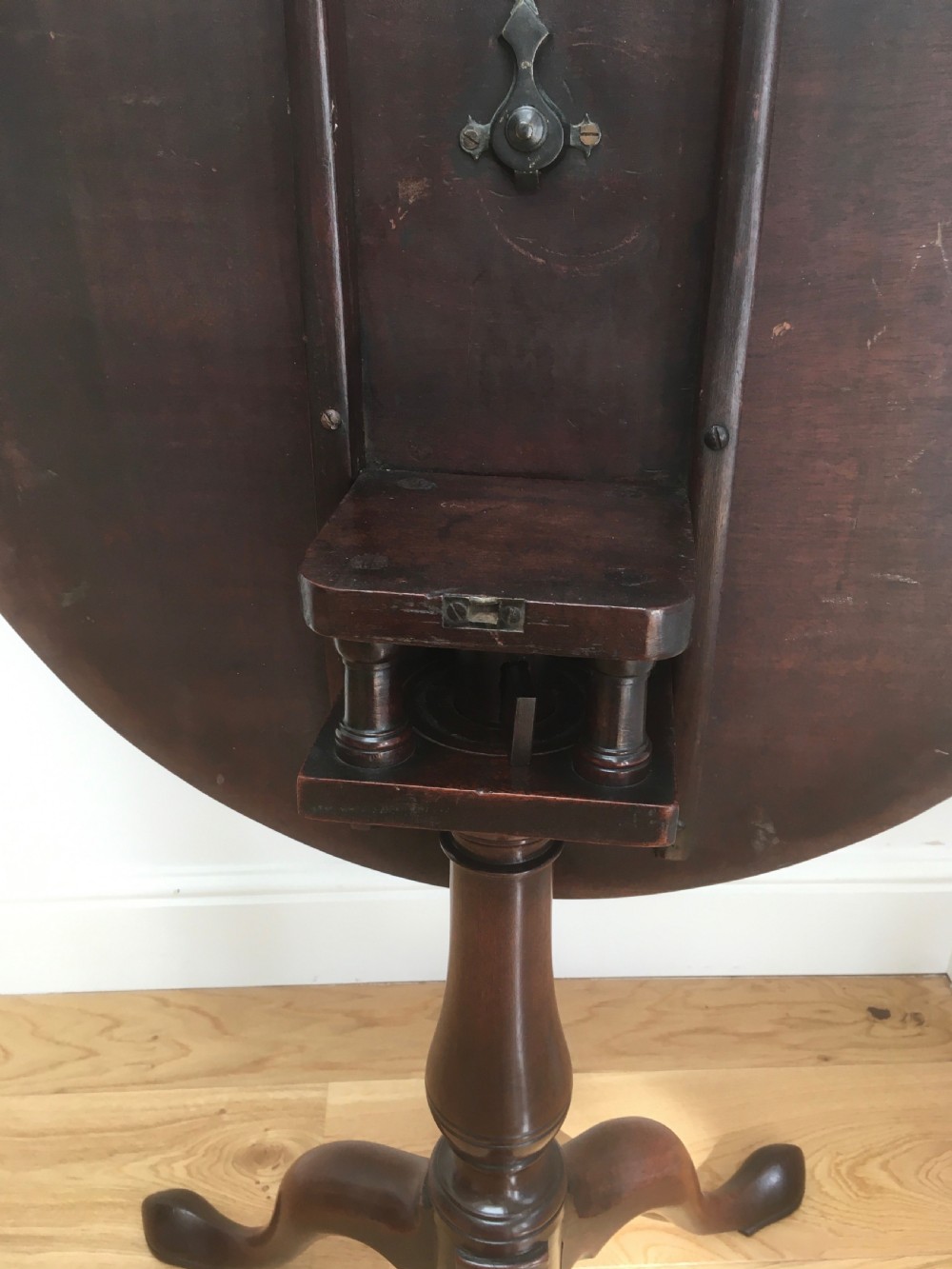 A Georgian mahogany tilt top table featuring a circular top, turned central pedestal, and tripod cabriole legs. View X