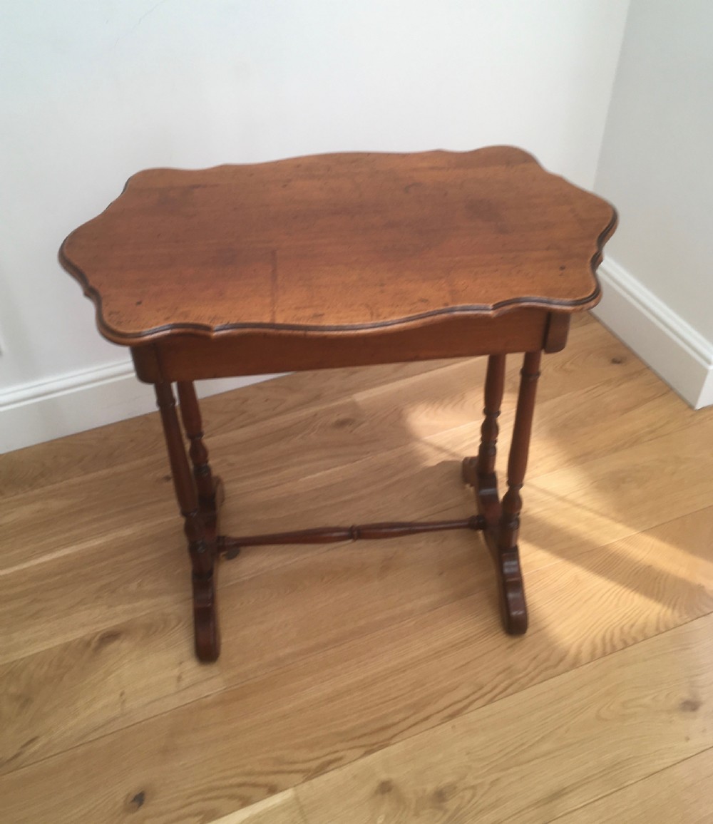 A Victorian mahogany side table featuring a serpentine top, turned legs with a stretcher base, and a single pull-out frieze drawer. View II