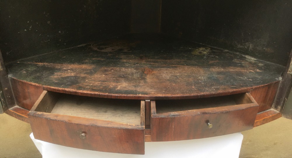 A Georgian mahogany bow-fronted corner cabinet featuring twin panelled doors, decorative inlay along the top cornice, and brass keyhole escutcheons. View III