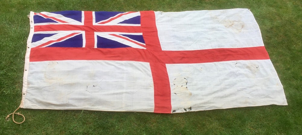 A rectangular Second World War Royal Navy White Ensign flag featuring a white field with a red Saint Georges Cross, a Union Jack canton, and a stitched canvas edge with rope lanyard.