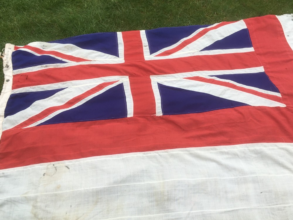 A rectangular Second World War Royal Navy White Ensign flag featuring a white field with a red Saint Georges Cross, a Union Jack canton, and a stitched canvas edge with rope lanyard. View III
