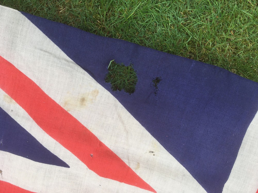 A rectangular Second World War Royal Navy White Ensign flag featuring a white field with a red Saint Georges Cross, a Union Jack canton, and a stitched canvas edge with rope lanyard. View IX