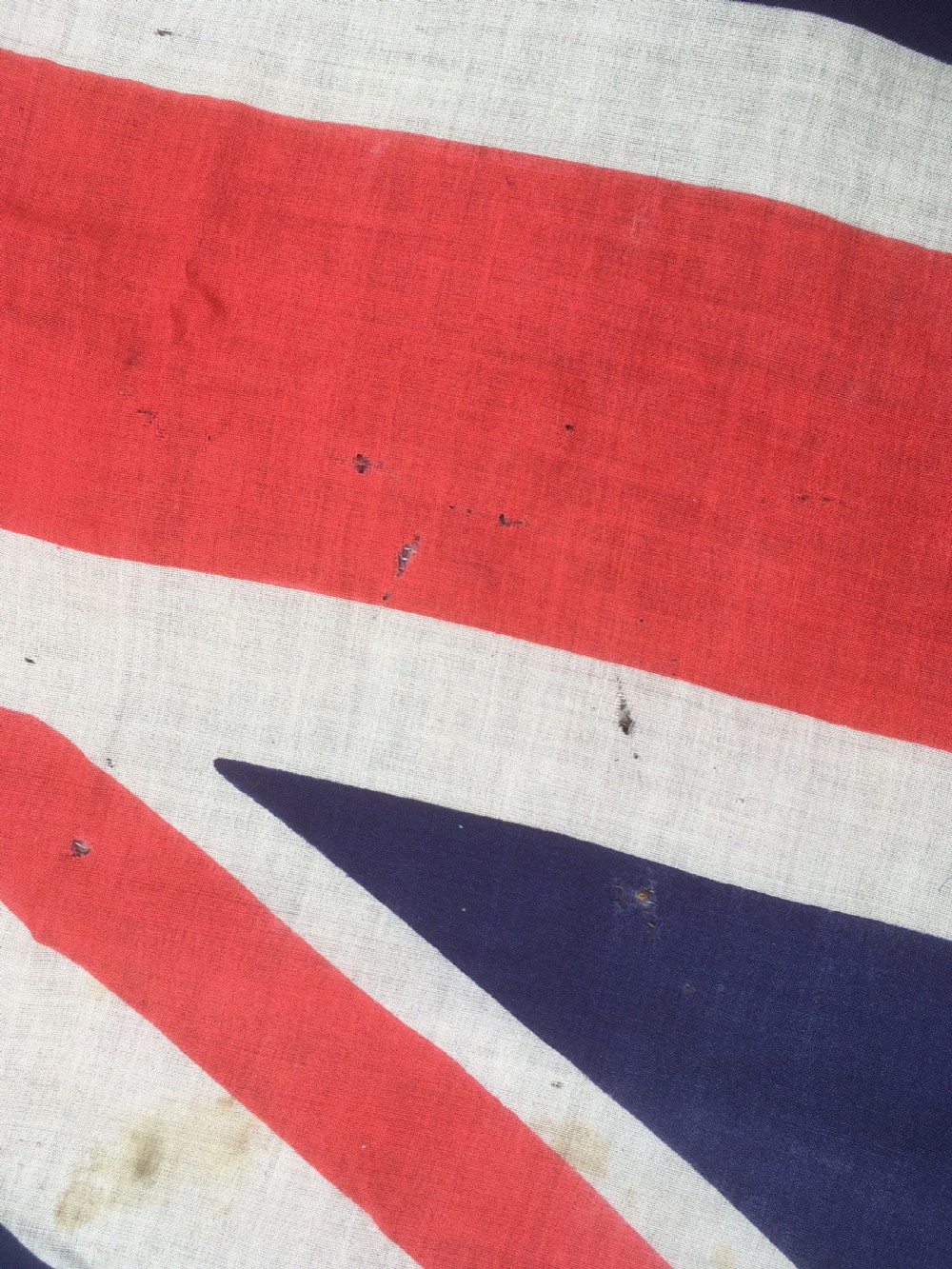 A rectangular Second World War Royal Navy White Ensign flag featuring a white field with a red Saint Georges Cross, a Union Jack canton, and a stitched canvas edge with rope lanyard. View X