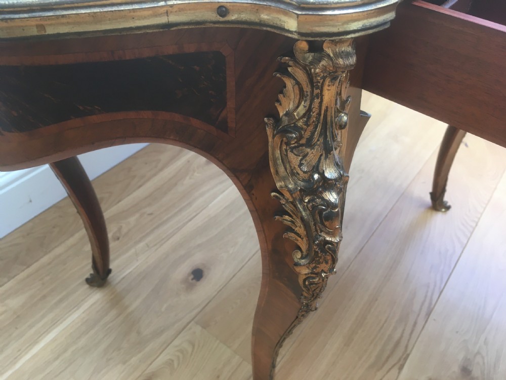 A Louis XV style shaped centre table featuring inlaid coromandel timber, curved cabriole legs, and gilded bronze mounts. View VI