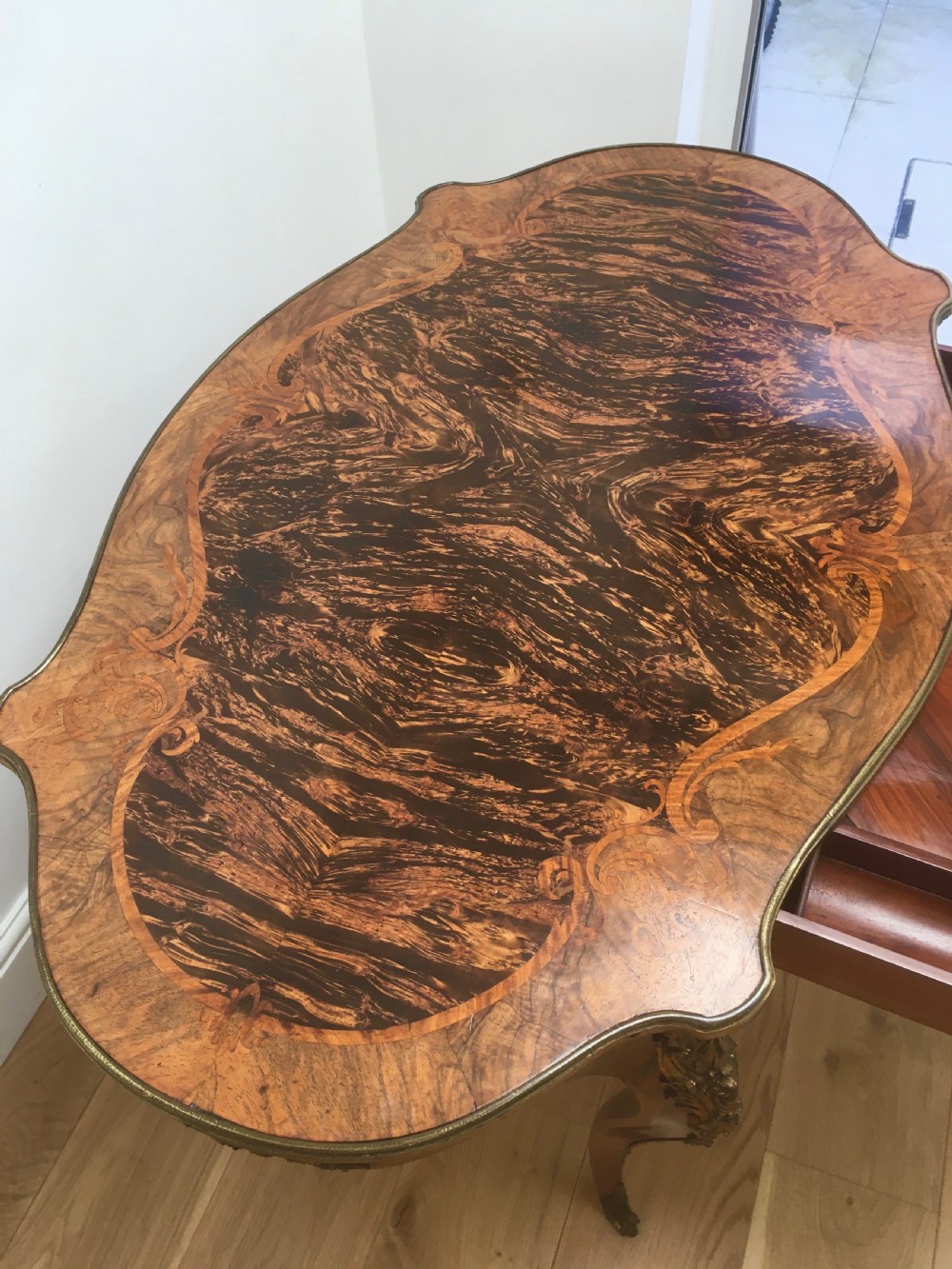 A Louis XV style shaped centre table featuring inlaid coromandel timber, curved cabriole legs, and gilded bronze mounts. View X