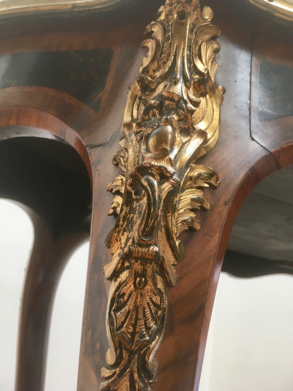 A Louis XV style shaped centre table featuring inlaid coromandel timber, curved cabriole legs, and gilded bronze mounts. View XI