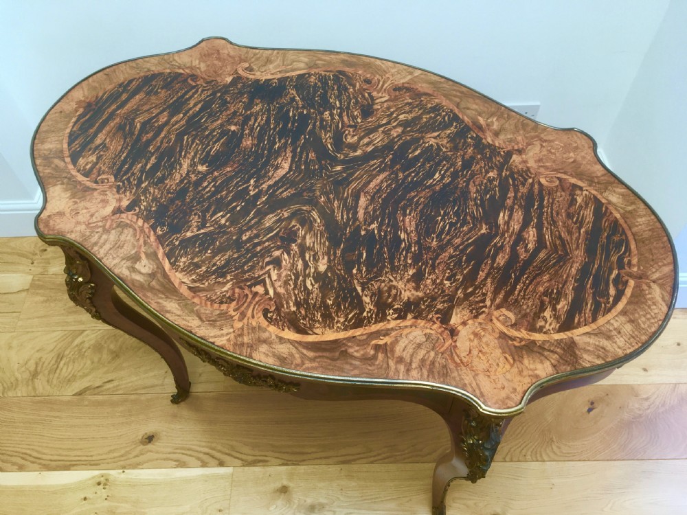 A Louis XV style shaped centre table featuring inlaid coromandel timber, curved cabriole legs, and gilded bronze mounts. View XV