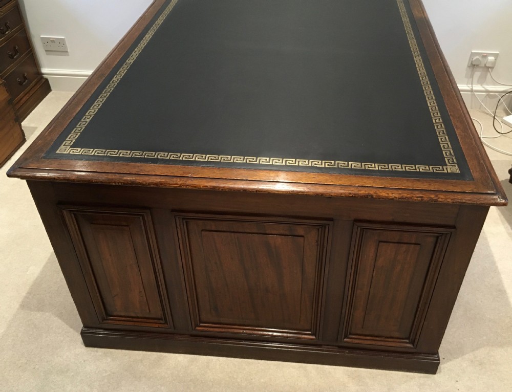 A large mahogany partners desk featuring a dark green gold-tooled leather writing surface and twin pedestals with turned knob handles. View III