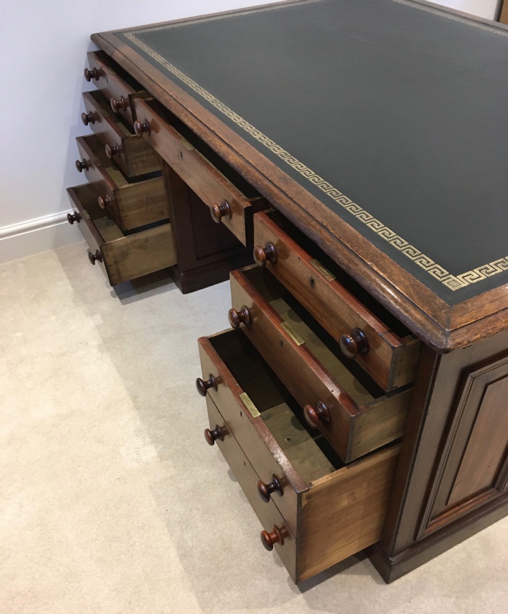 A large mahogany partners desk featuring a dark green gold-tooled leather writing surface and twin pedestals with turned knob handles. View IV