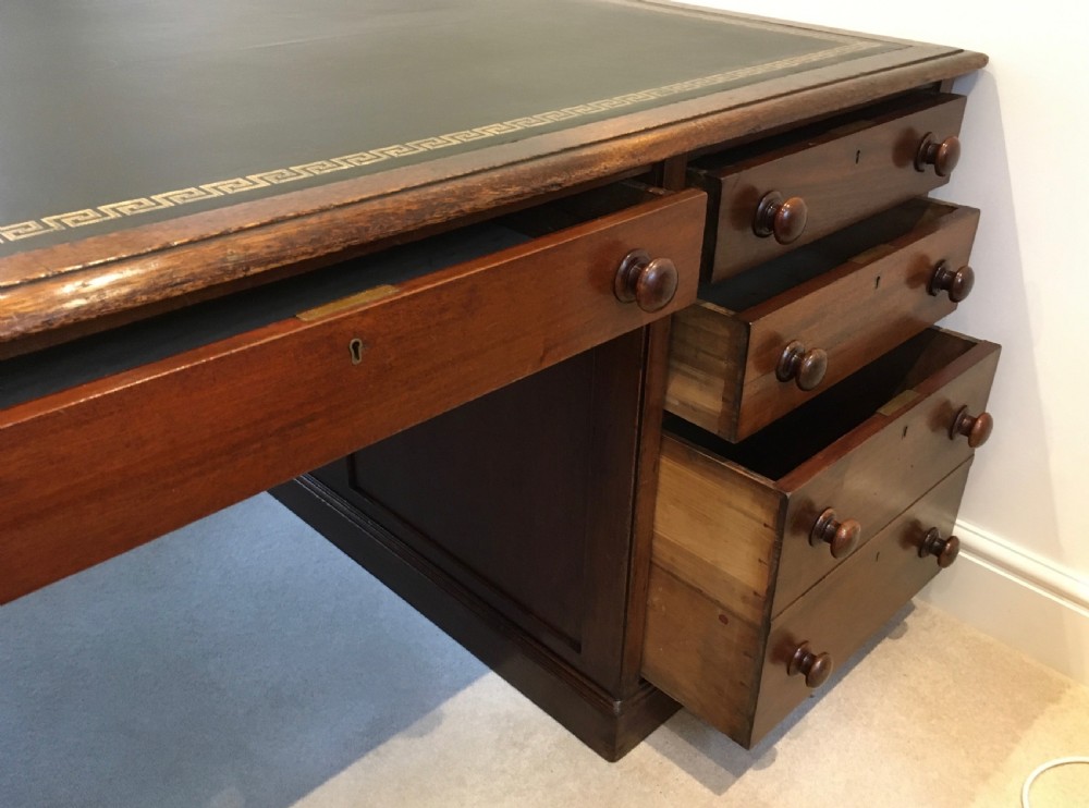 A large mahogany partners desk featuring a dark green gold-tooled leather writing surface and twin pedestals with turned knob handles. View VI