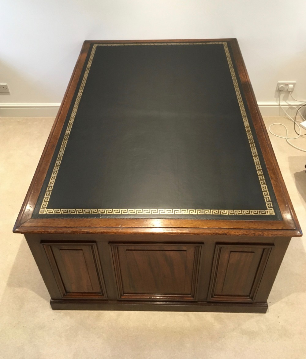 A large mahogany partners desk featuring a dark green gold-tooled leather writing surface and twin pedestals with turned knob handles. View VII