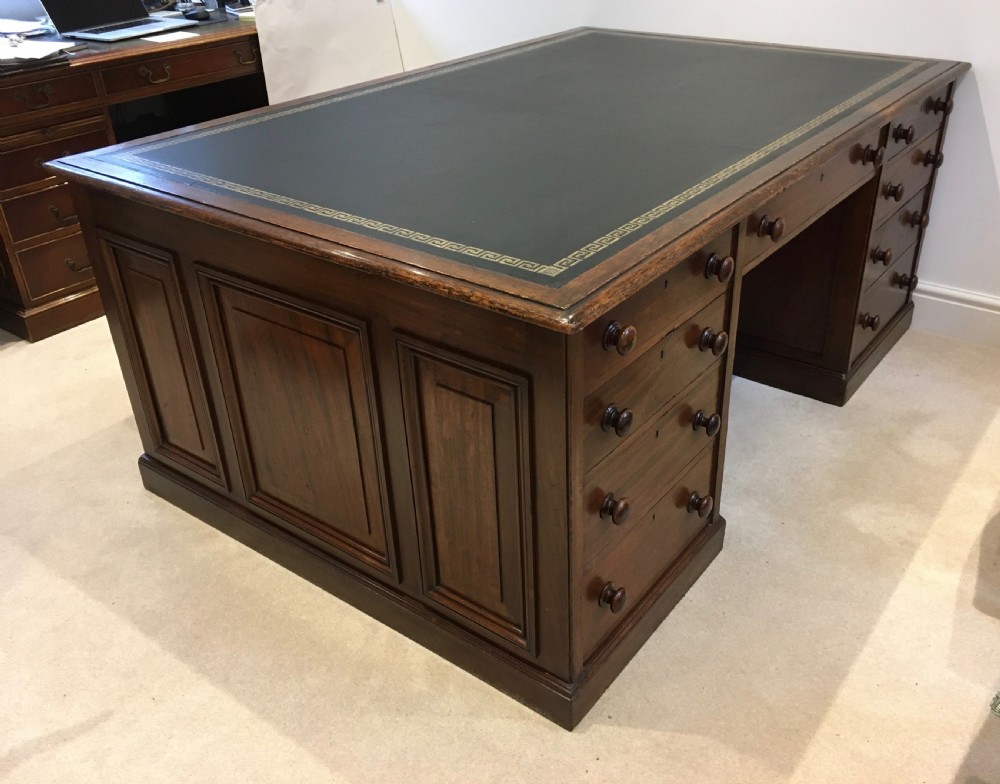 A large mahogany partners desk featuring a dark green gold-tooled leather writing surface and twin pedestals with turned knob handles. View VIII