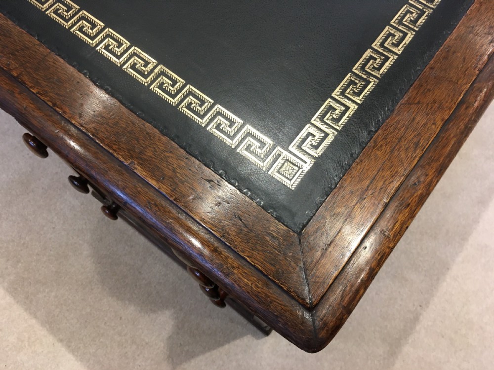 A large mahogany partners desk featuring a dark green gold-tooled leather writing surface and twin pedestals with turned knob handles. View IX