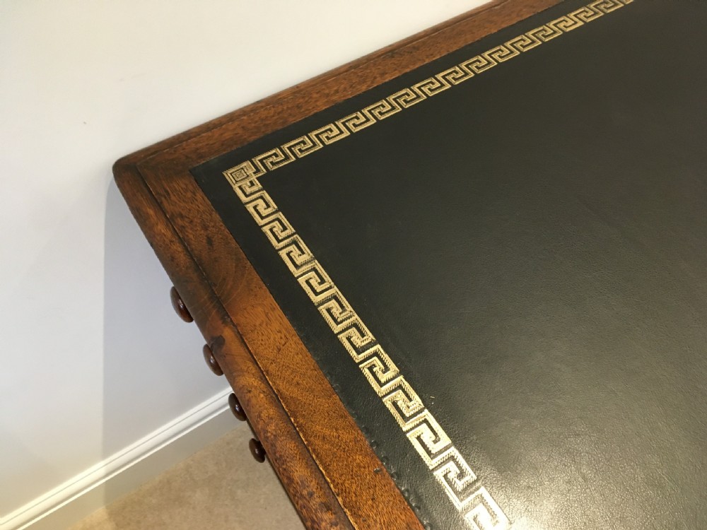 A large mahogany partners desk featuring a dark green gold-tooled leather writing surface and twin pedestals with turned knob handles. View X