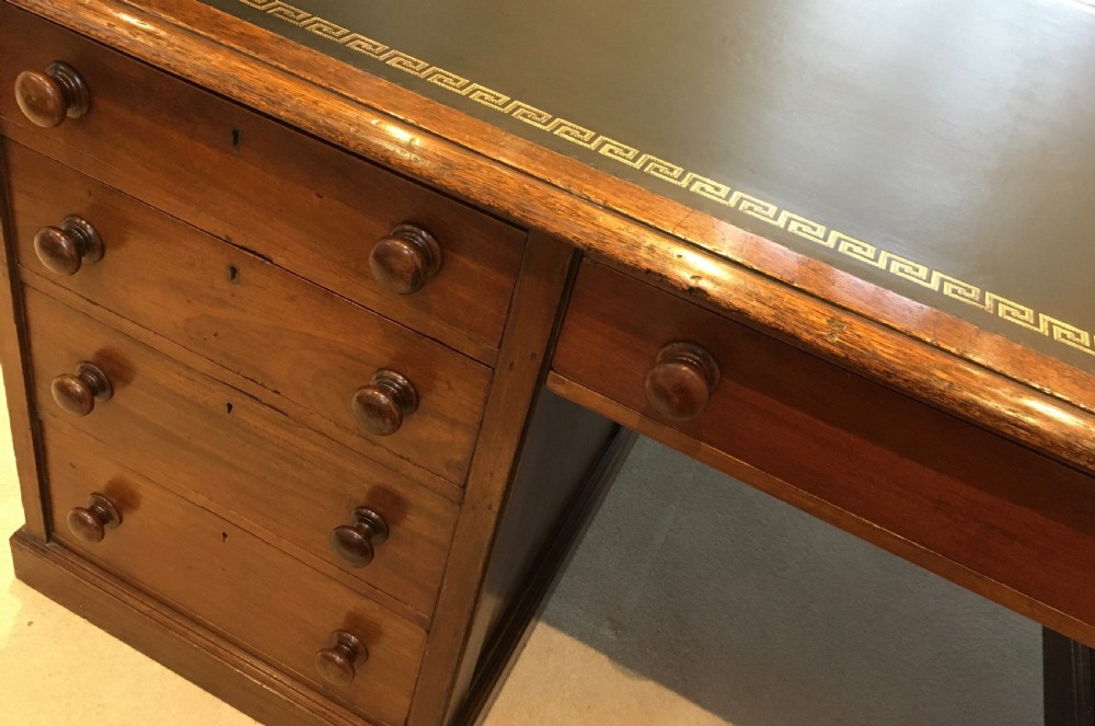 A large mahogany partners desk featuring a dark green gold-tooled leather writing surface and twin pedestals with turned knob handles. View XII