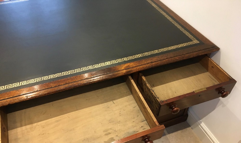 A large mahogany partners desk featuring a dark green gold-tooled leather writing surface and twin pedestals with turned knob handles. View XIV