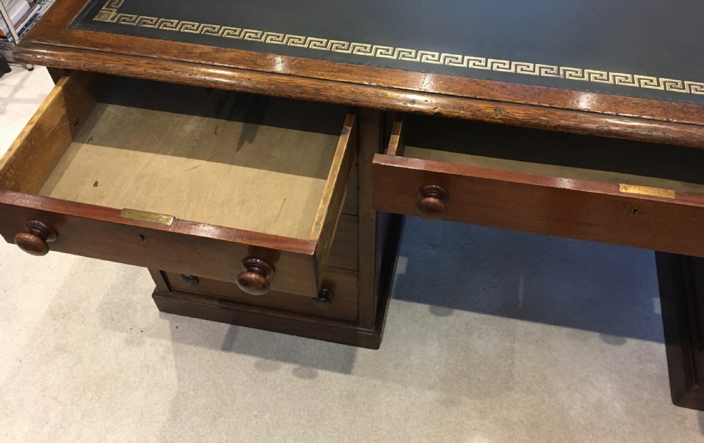 A large mahogany partners desk featuring a dark green gold-tooled leather writing surface and twin pedestals with turned knob handles. View XV
