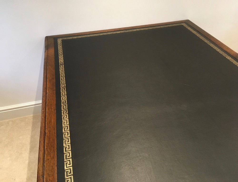 A large mahogany partners desk featuring a dark green gold-tooled leather writing surface and twin pedestals with turned knob handles. View XVI