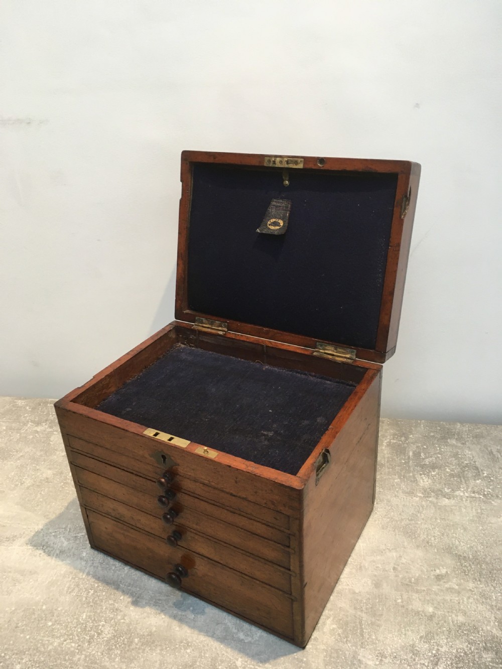 A Victorian mahogany instrument chest featuring a hinged top lid and five graduated drawers lined with dark blue velvet. View VIII