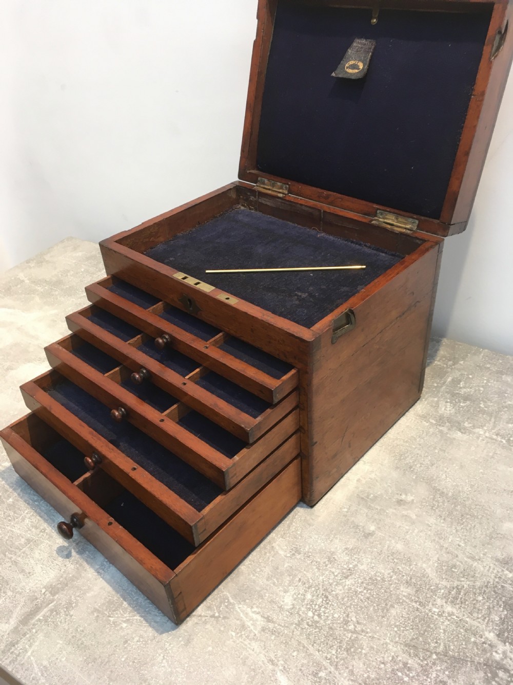 A Victorian mahogany instrument chest featuring a hinged top lid and five graduated drawers lined with dark blue velvet. View XII