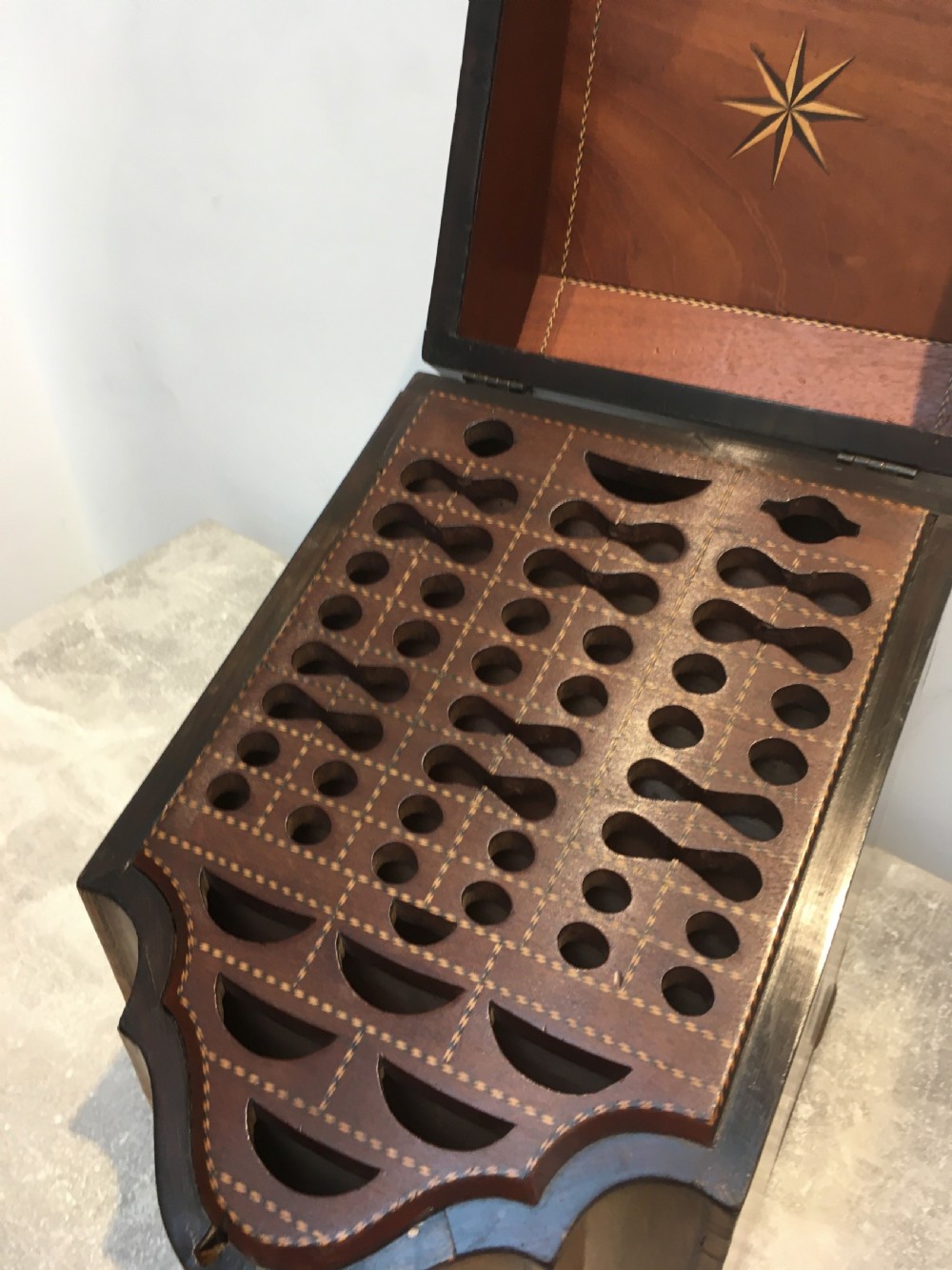 A George III mahogany slanted-top knife box shown open, featuring slotted interior fittings, string inlay, and a star marquetry motif on the inside lid. View III