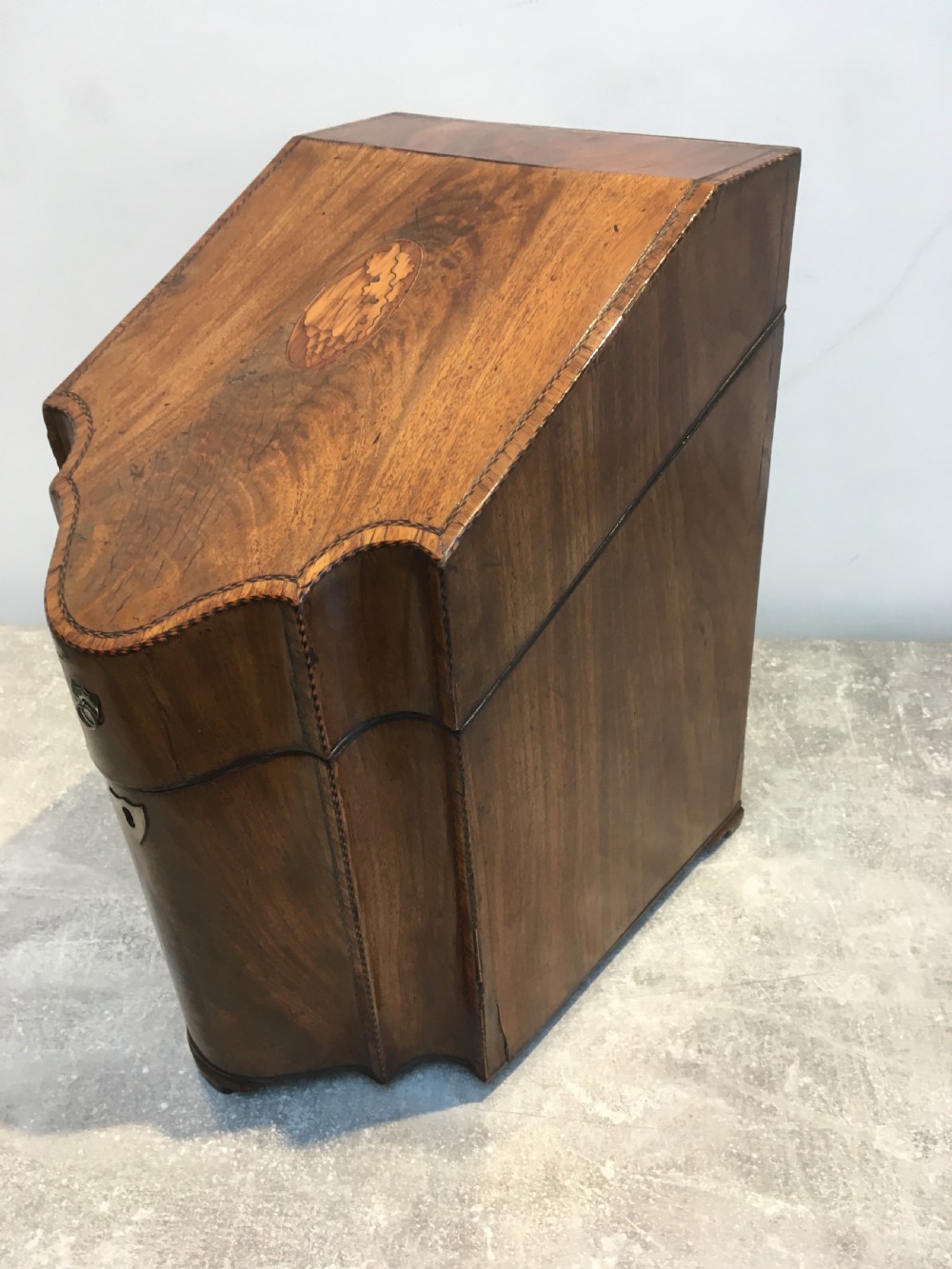 A George III mahogany slanted-top knife box shown open, featuring slotted interior fittings, string inlay, and a star marquetry motif on the inside lid. View VI