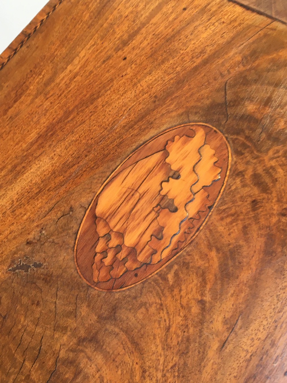 A George III mahogany slanted-top knife box shown open, featuring slotted interior fittings, string inlay, and a star marquetry motif on the inside lid. View IX