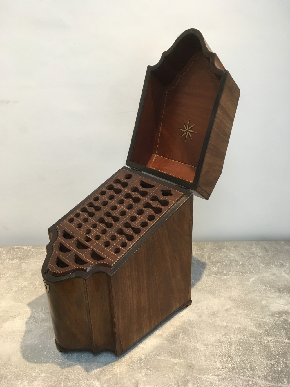 A George III mahogany slanted-top knife box shown open, featuring slotted interior fittings, string inlay, and a star marquetry motif on the inside lid. View XIII