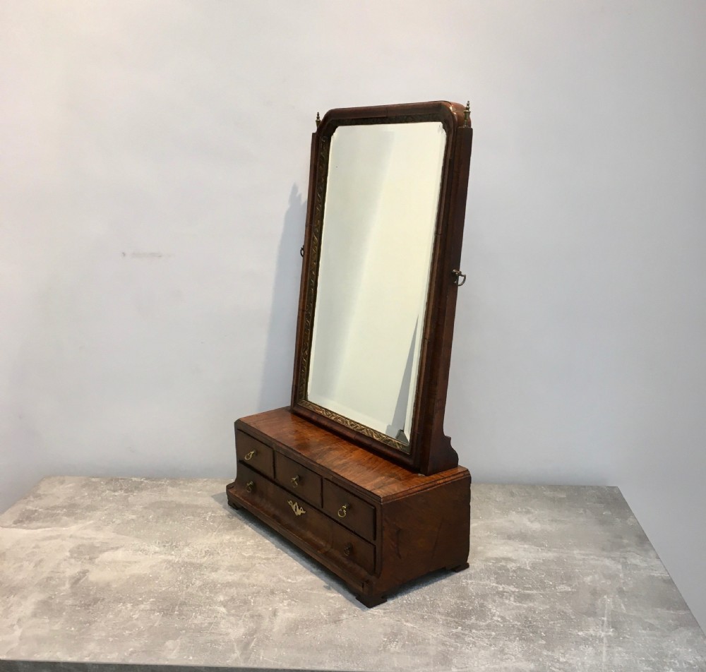 An 18th-century walnut toilet mirror featuring an adjustable rectangular glass frame set above a stepped base with small drawers and brass drop handles. View VIII