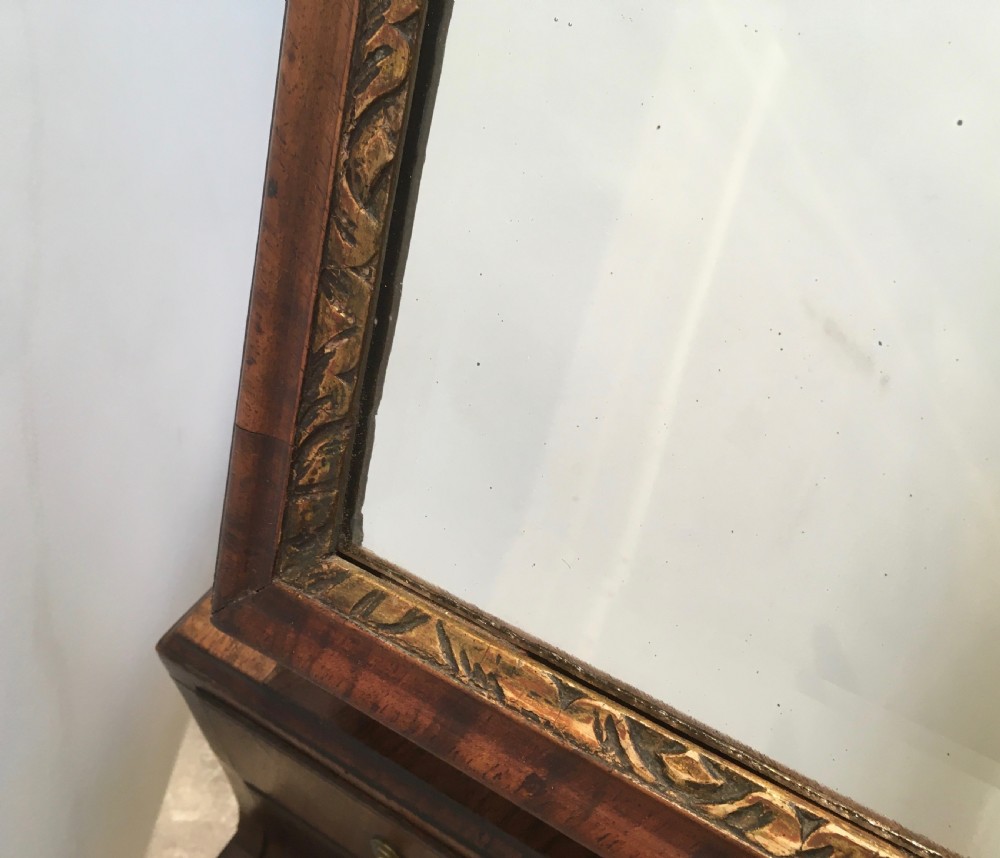 An 18th-century walnut toilet mirror featuring an adjustable rectangular glass frame set above a stepped base with small drawers and brass drop handles. View X