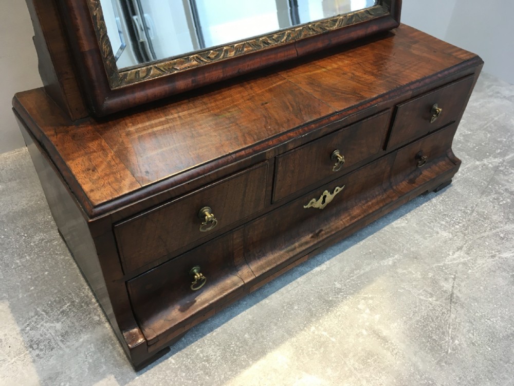 An 18th-century walnut toilet mirror featuring an adjustable rectangular glass frame set above a stepped base with small drawers and brass drop handles. View XIII