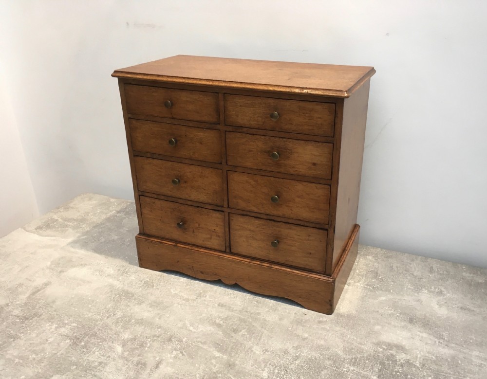 A nineteenth-century medium brown oak collectors chest featuring eight small drawers arranged in two columns with round metal knobs. View II