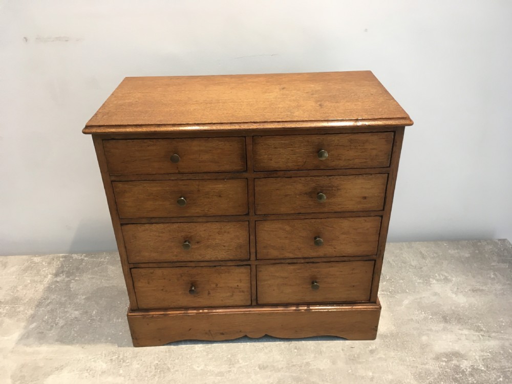 A nineteenth-century medium brown oak collectors chest featuring eight small drawers arranged in two columns with round metal knobs. View IV