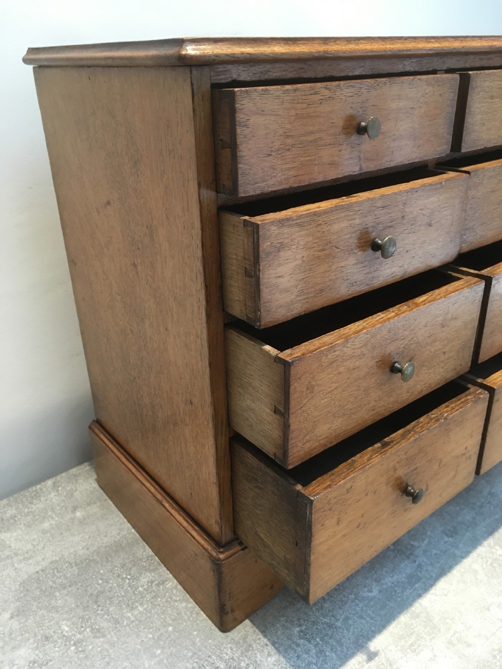 A nineteenth-century medium brown oak collectors chest featuring eight small drawers arranged in two columns with round metal knobs. View VI