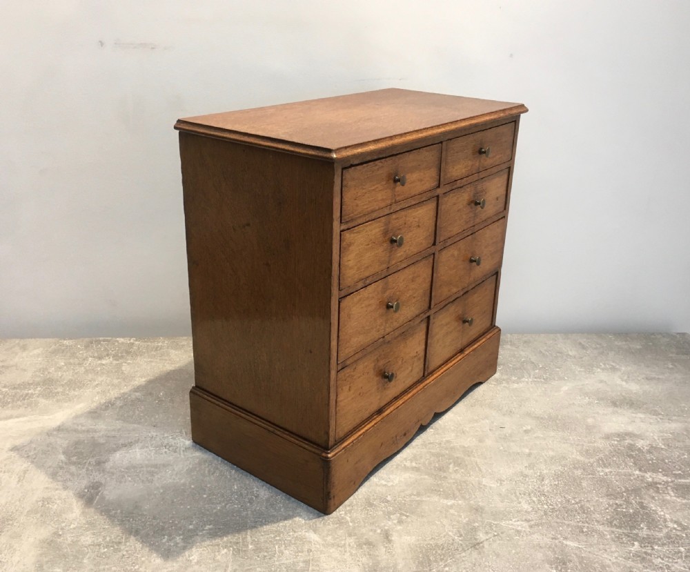 A nineteenth-century medium brown oak collectors chest featuring eight small drawers arranged in two columns with round metal knobs. View VIII