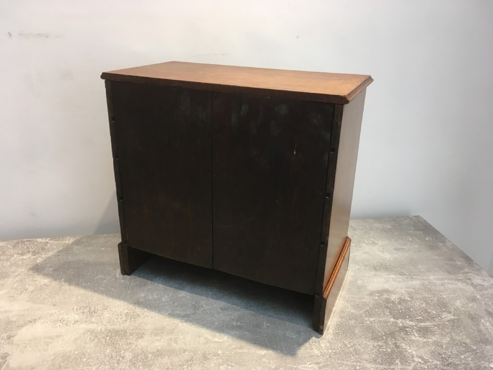A nineteenth-century medium brown oak collectors chest featuring eight small drawers arranged in two columns with round metal knobs. View IX