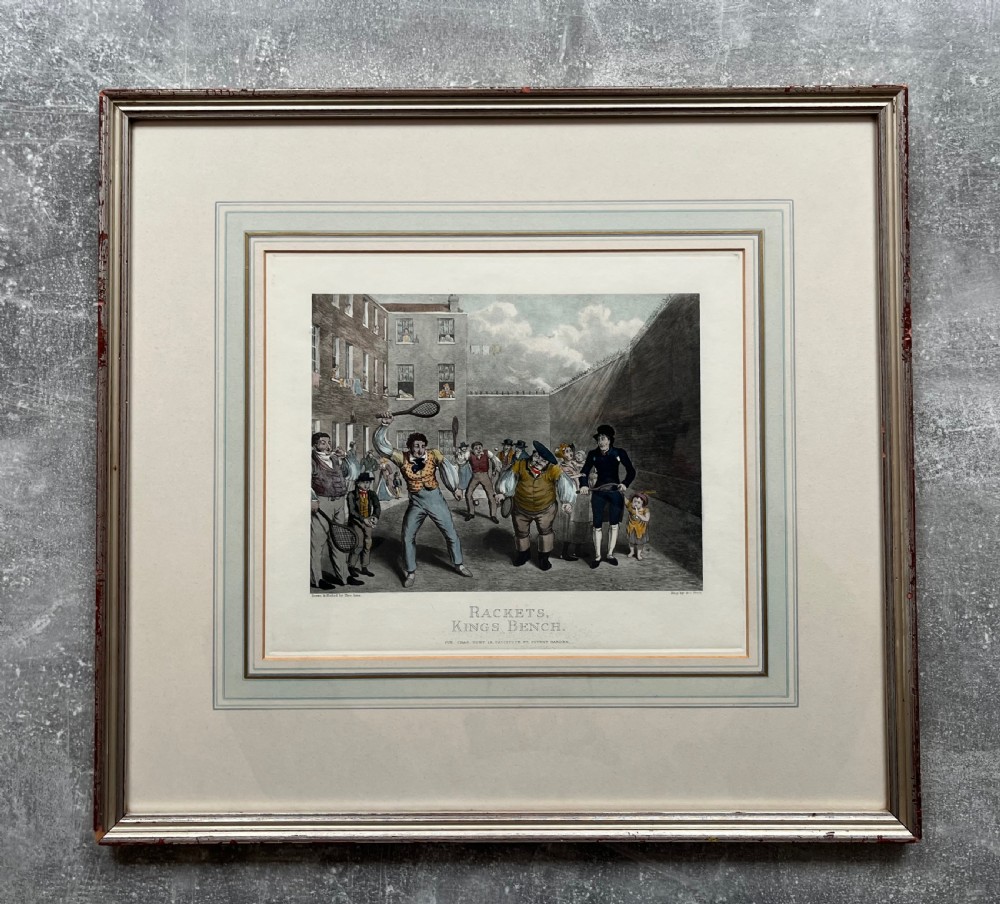 Framed hand-coloured nineteenth-century print depicting figures playing rackets in a prison courtyard. View VII