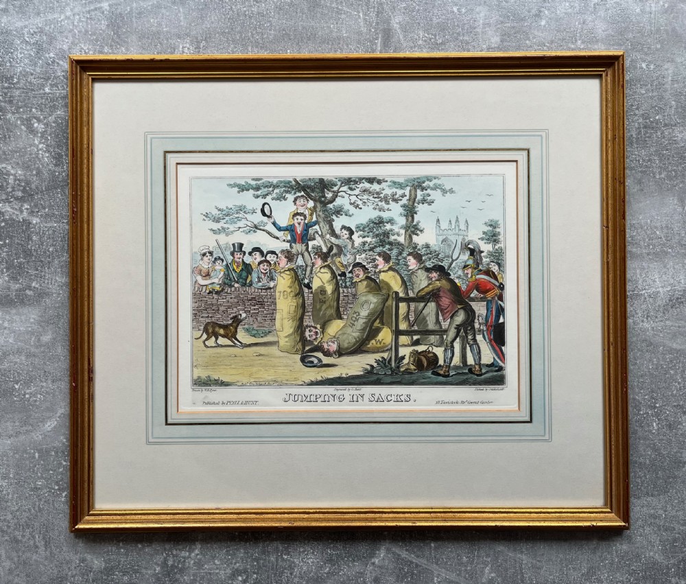 A framed Georgian hand-coloured satirical print titled Jumping in Sacks depicting figures participating in a sack race within a gilded wood frame and lined cream mount. View VIII