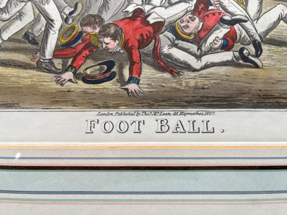 A framed Georgian hand-coloured engraving depicting men in military attire playing football, set within a lined mount and a gilded wooden frame. View III