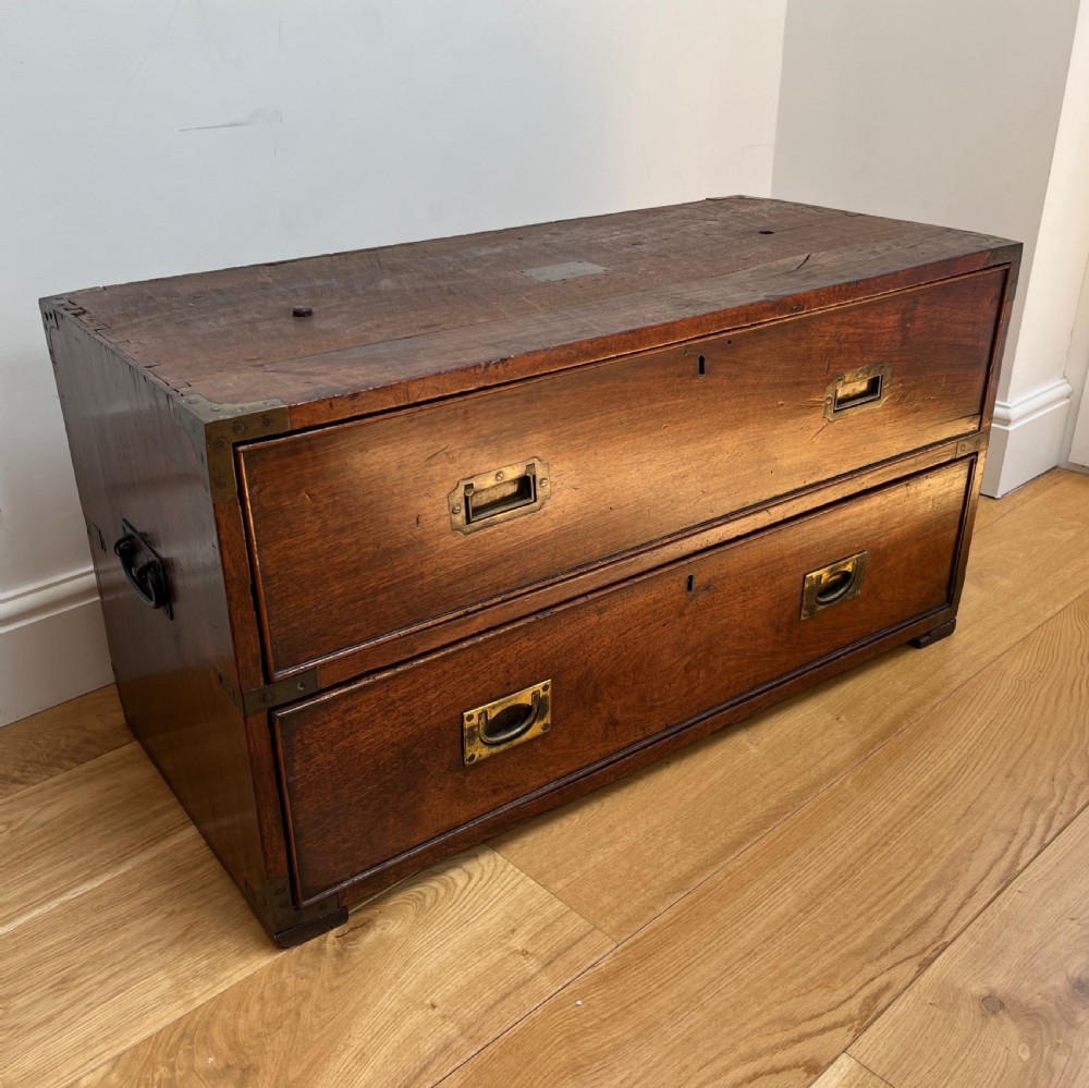 A teak campaign secretaire chest featuring brass corner brackets, flush brass drawer handles, and an open fall-front writing surface lined with green felt. View XIII