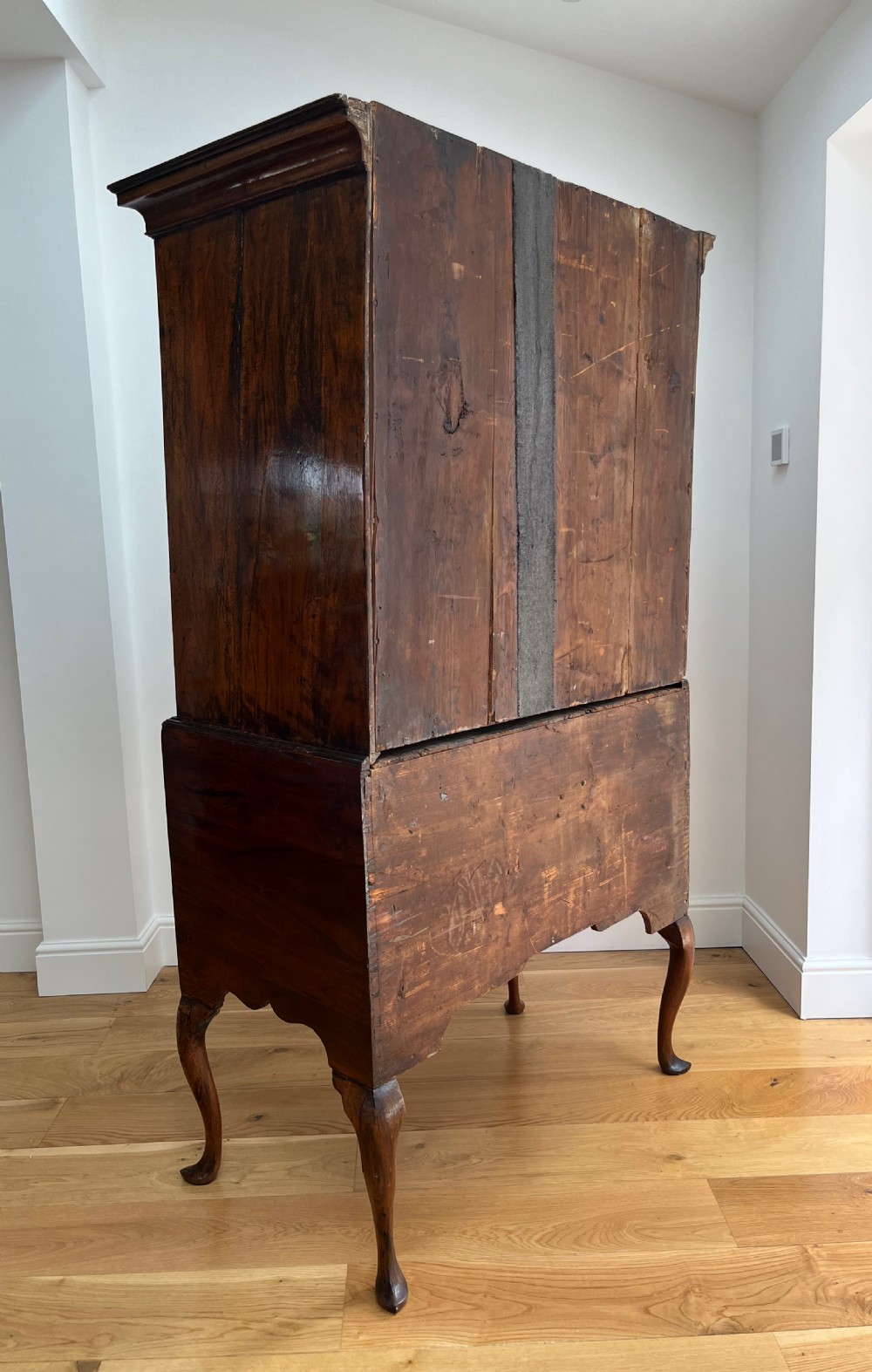 An early 18th-century walnut chest on stand featuring graduated drawers, decorative brass handles, a shaped apron, and four cabriole legs. View VI