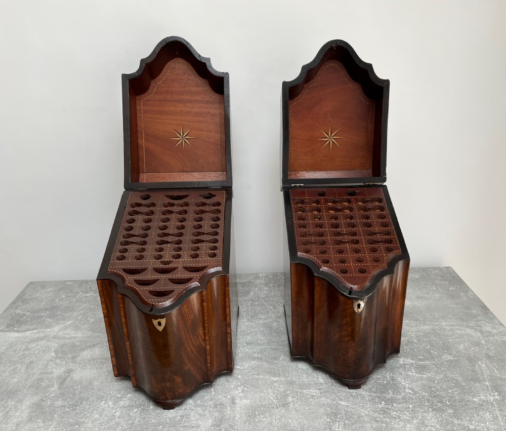 A matched pair of George III flame mahogany knife boxes featuring sloped lids with shell marquetry inlays and serpentine fronts. View II