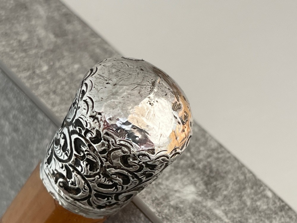 A late Victorian Malacca cane sword stick featuring a silver repousse embossed knop handle and a concealed steel blade alongside its wooden sheath. View VI