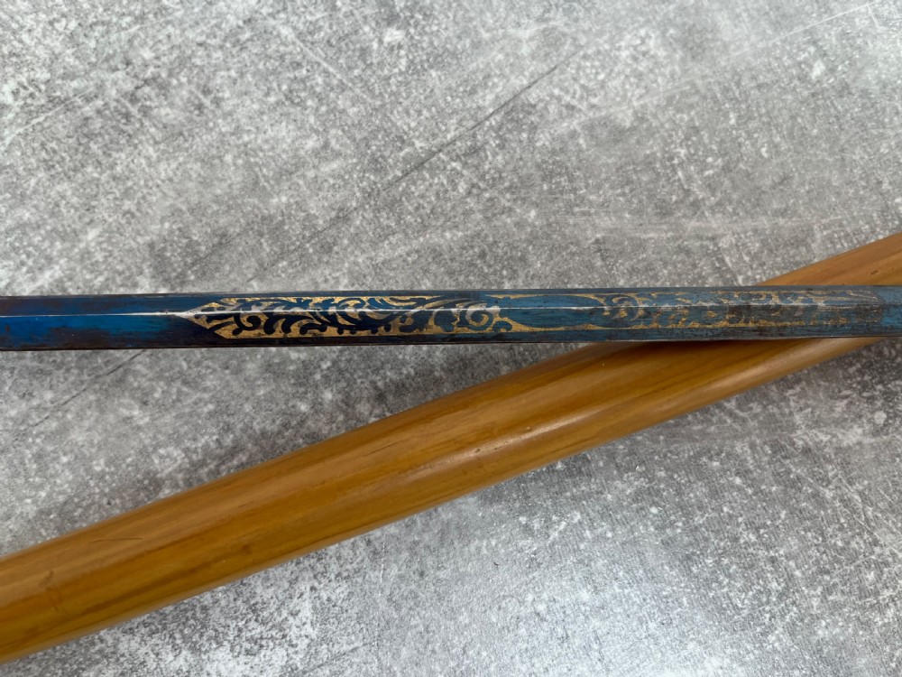 A late Victorian Malacca cane sword stick featuring a silver repousse embossed knop handle and a concealed steel blade alongside its wooden sheath. View XI