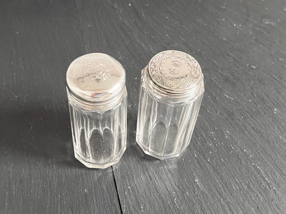 Pair of faceted clear cut glass vanity jars fitted with silver tops featuring engraved and chased detailing. View III