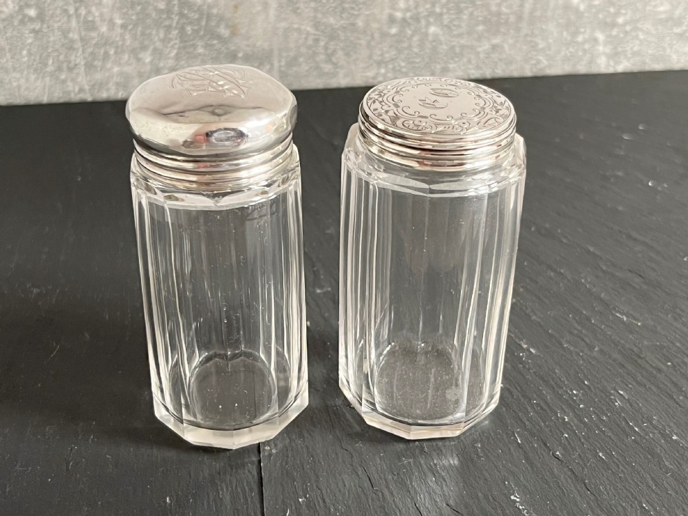 Pair of faceted clear cut glass vanity jars fitted with silver tops featuring engraved and chased detailing. View XII